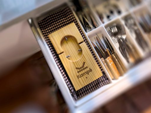 El jamonero que cabe en un cajón Cajón de utensilios de cocina con una tabla de cortar de madera y diversos instrumentos.